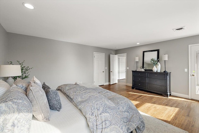bedroom with visible vents, recessed lighting, baseboards, and wood finished floors