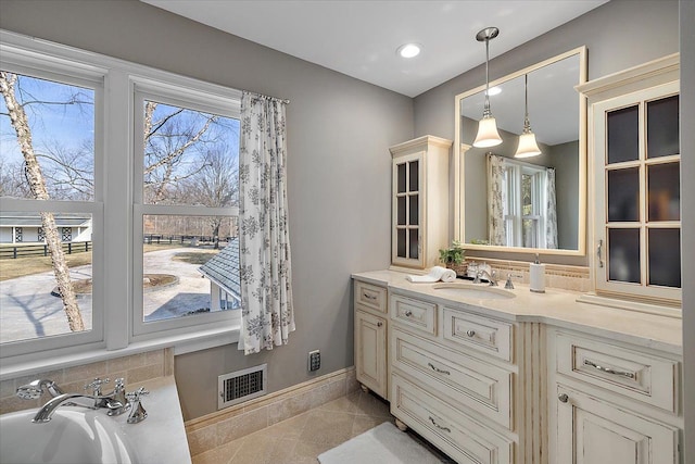 bathroom with baseboards, vanity, recessed lighting, and visible vents
