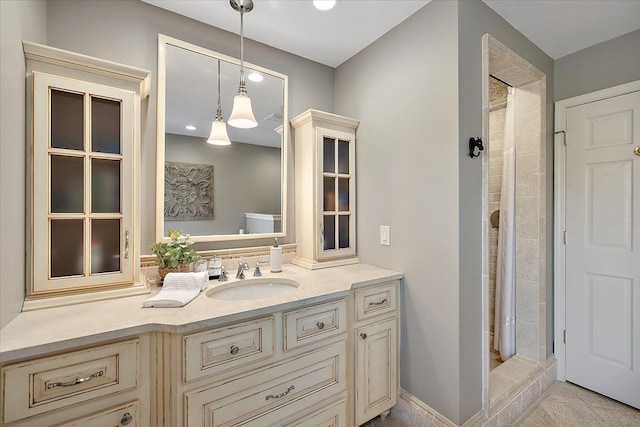 full bath featuring recessed lighting, a tile shower, and vanity