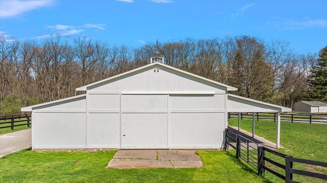 view of outdoor structure featuring fence and an outdoor structure