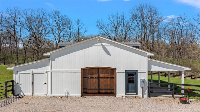 view of outbuilding featuring fence, an outdoor structure, and an exterior structure