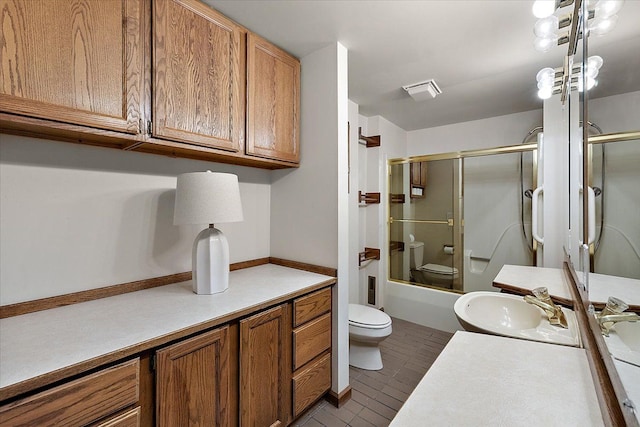full bath featuring vanity, toilet, tile patterned floors, enclosed tub / shower combo, and visible vents