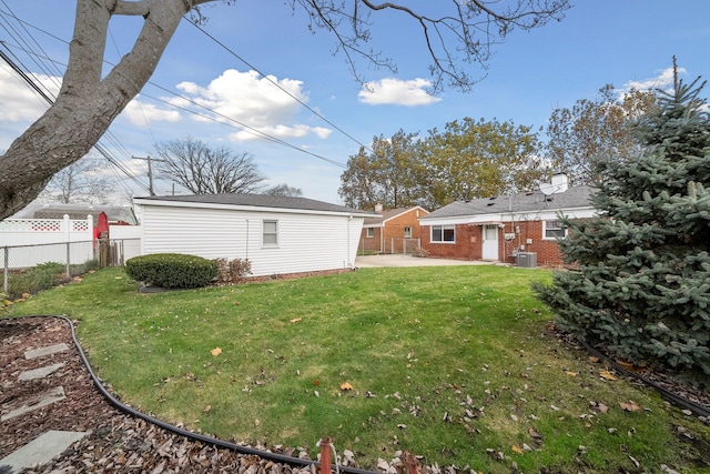 view of yard with a patio area, an outdoor structure, fence, and central air condition unit