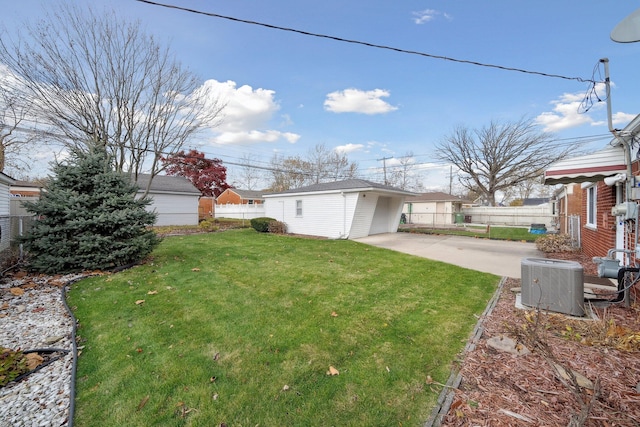 view of yard featuring an outbuilding, fence, and central AC unit