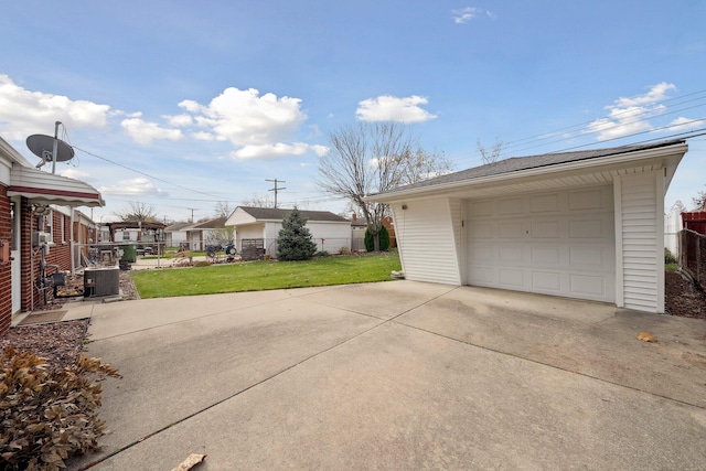 detached garage featuring concrete driveway, central AC, and fence