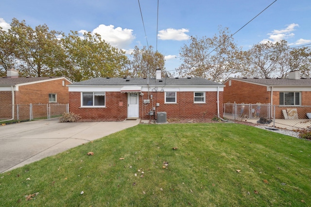 back of house featuring a lawn, fence, cooling unit, and brick siding