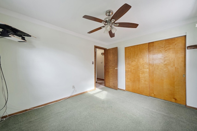 unfurnished bedroom featuring carpet floors, ceiling fan, baseboards, and a closet