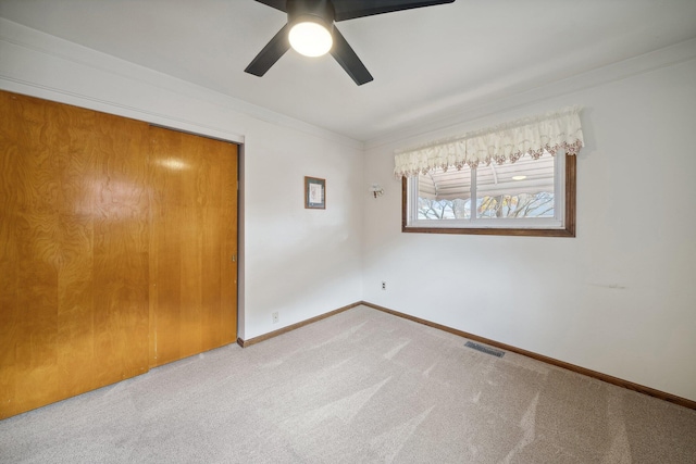 unfurnished bedroom featuring carpet floors, a closet, visible vents, and baseboards