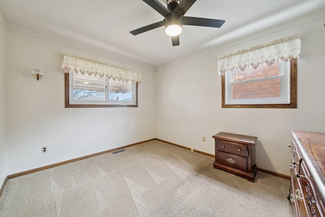 unfurnished bedroom featuring baseboards, ornamental molding, visible vents, and light colored carpet