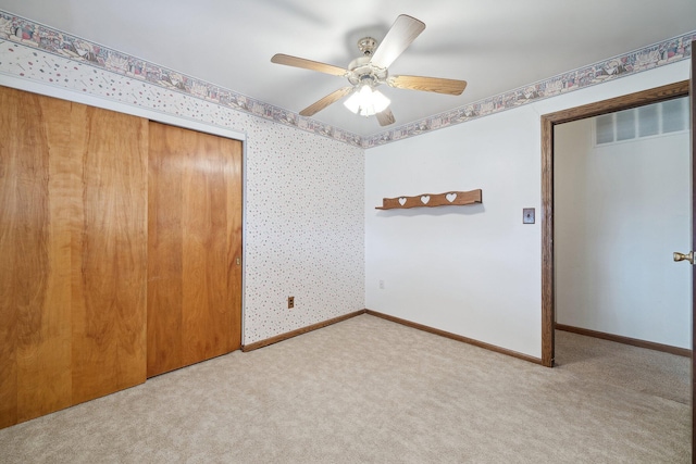 unfurnished room featuring a ceiling fan, carpet flooring, baseboards, and wallpapered walls