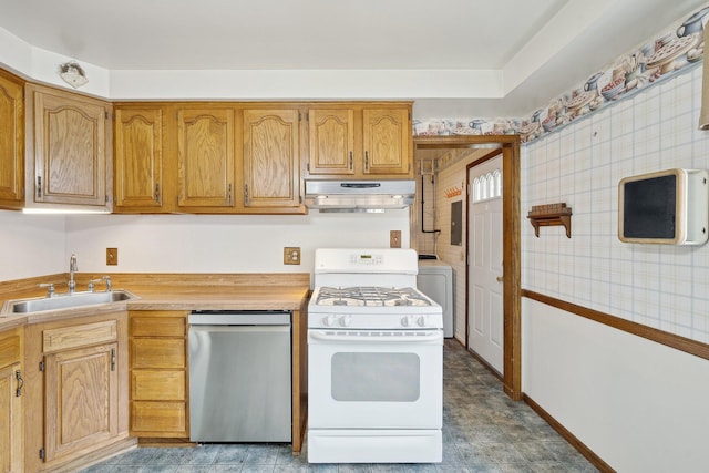 kitchen with dishwasher, washer / clothes dryer, gas range gas stove, under cabinet range hood, and a sink