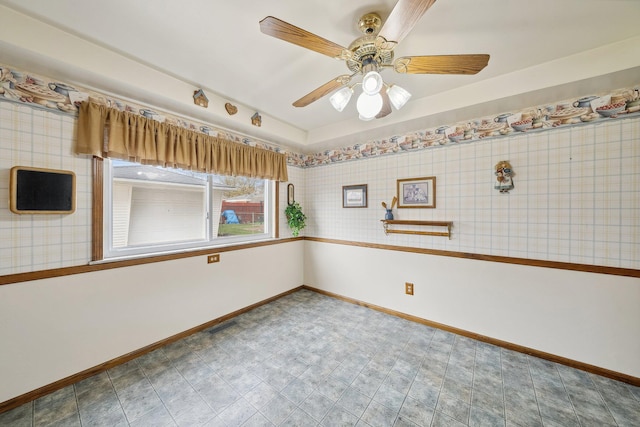 spare room with wallpapered walls, visible vents, baseboards, and a ceiling fan