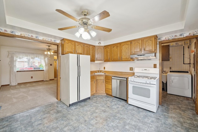 kitchen with light colored carpet, light countertops, washer / dryer, white appliances, and under cabinet range hood