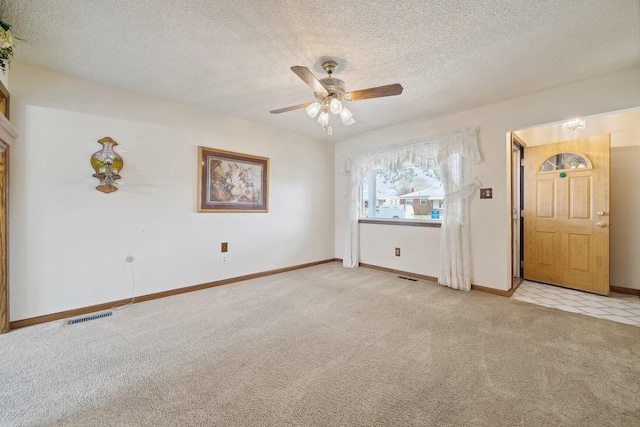 unfurnished room with baseboards, visible vents, light carpet, and a textured ceiling