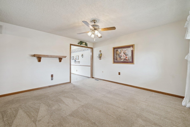 empty room with a textured ceiling, ceiling fan, visible vents, baseboards, and carpet