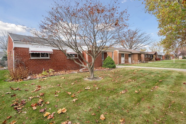 ranch-style home featuring brick siding and a front yard