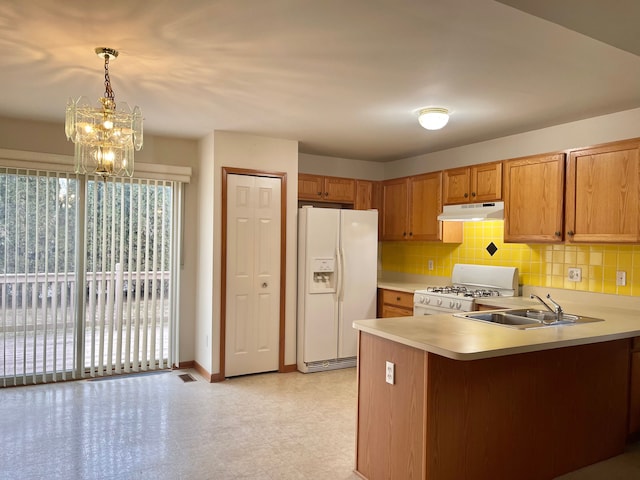 kitchen with under cabinet range hood, a peninsula, white appliances, a sink, and light countertops