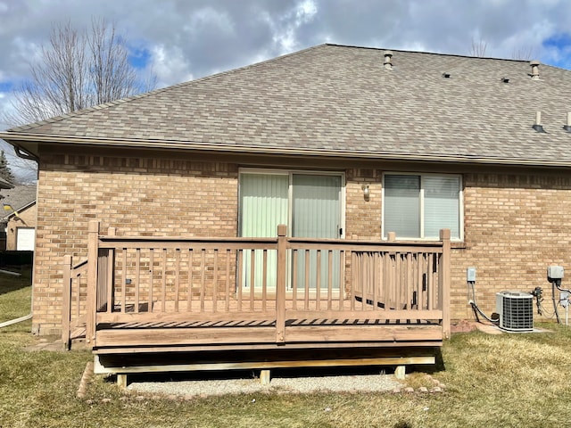 rear view of house featuring a shingled roof, a deck, cooling unit, and brick siding