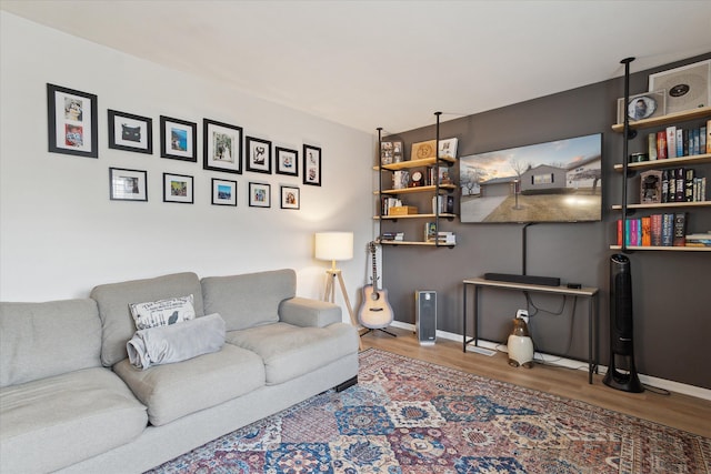 living area with baseboards and wood finished floors