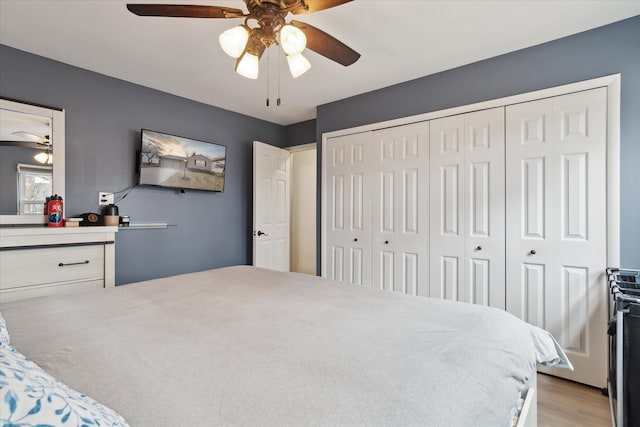 bedroom featuring a closet, ceiling fan, and light wood finished floors