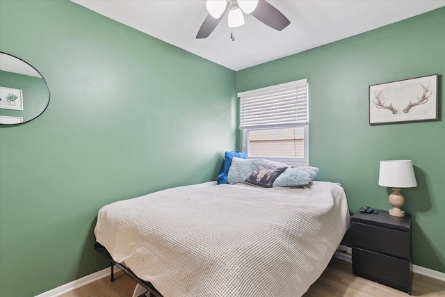 bedroom with a ceiling fan, baseboards, and wood finished floors