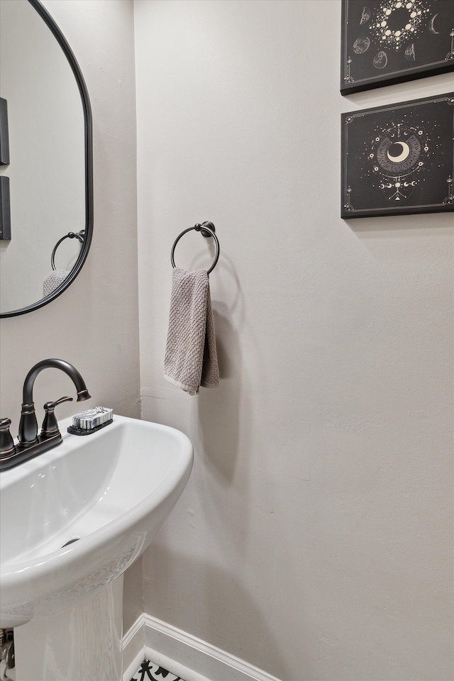 bathroom with a sink and baseboards