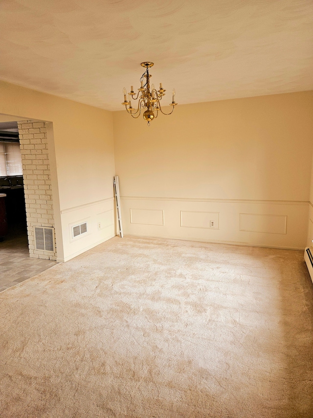 carpeted spare room featuring visible vents and a chandelier