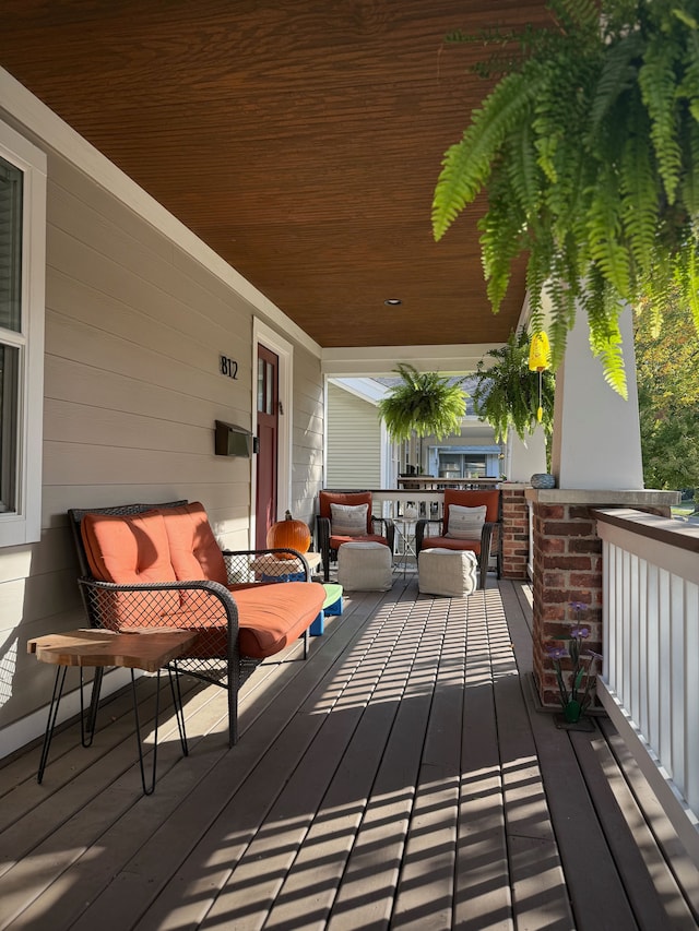 wooden deck with covered porch and an outdoor living space