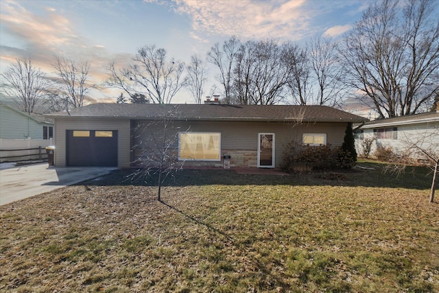 view of front facade featuring driveway, an attached garage, and a yard