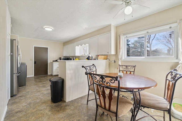 dining space with a ceiling fan, a textured ceiling, baseboards, and finished concrete flooring