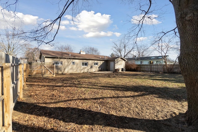 back of house with a yard, a chimney, a patio area, and a fenced backyard