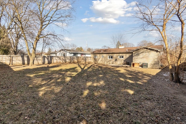 back of house featuring a fenced backyard and a chimney