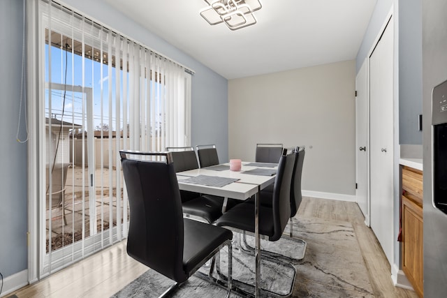 dining room with light wood-type flooring and baseboards