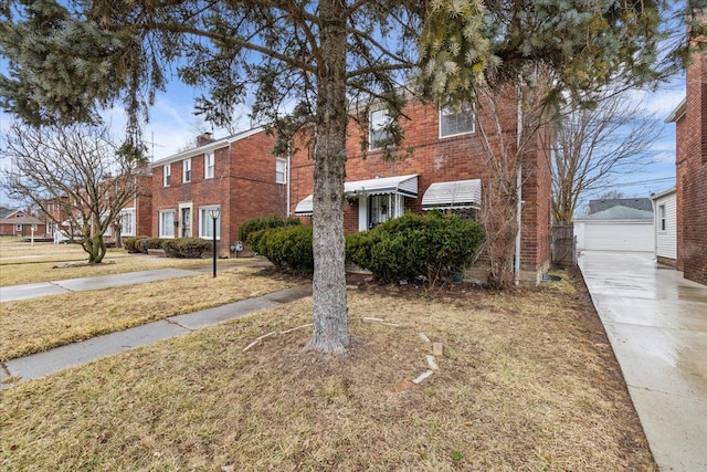 townhome / multi-family property featuring a garage, an outbuilding, brick siding, and a chimney