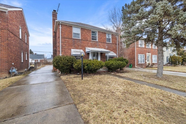 townhome / multi-family property with brick siding and a chimney