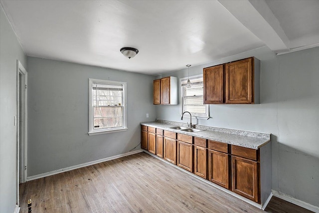 kitchen featuring plenty of natural light, light countertops, a sink, and light wood-style flooring