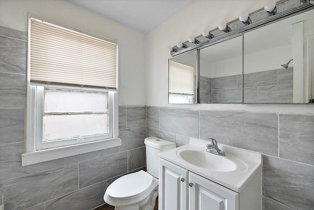 bathroom featuring tile walls, toilet, and vanity