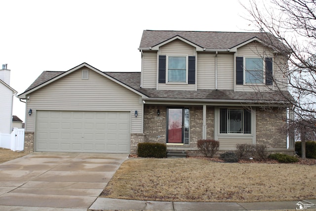 traditional-style home with a garage, brick siding, a shingled roof, concrete driveway, and a front lawn