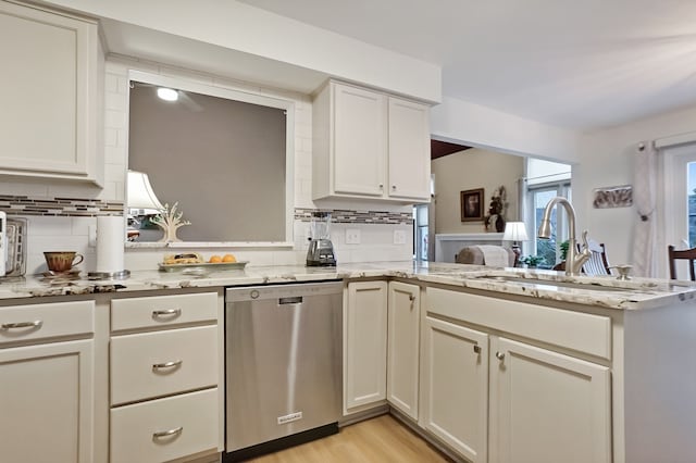 kitchen featuring decorative backsplash, dishwasher, light stone counters, a peninsula, and light wood-style floors