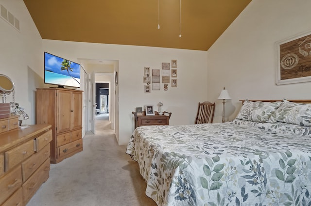 bedroom featuring light colored carpet, visible vents, and lofted ceiling