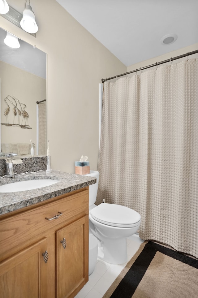 full bathroom with toilet, vanity, and tile patterned floors