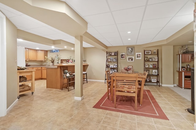 dining area with a paneled ceiling, light tile patterned floors, baseboards, and recessed lighting