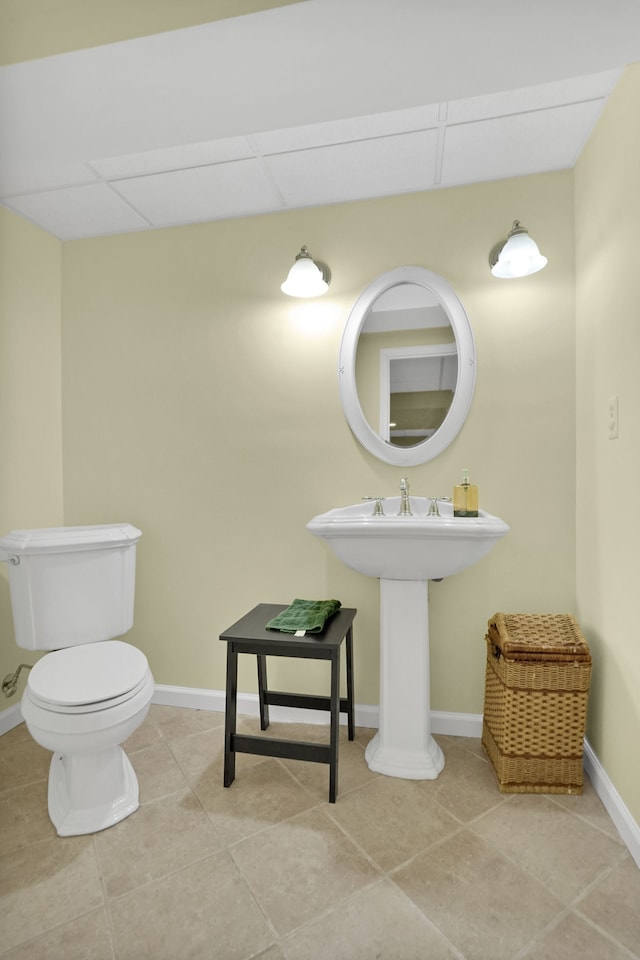 bathroom featuring toilet, baseboards, a paneled ceiling, and tile patterned floors