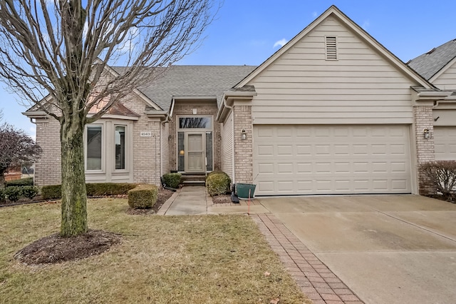 ranch-style house with brick siding, roof with shingles, a garage, driveway, and a front lawn