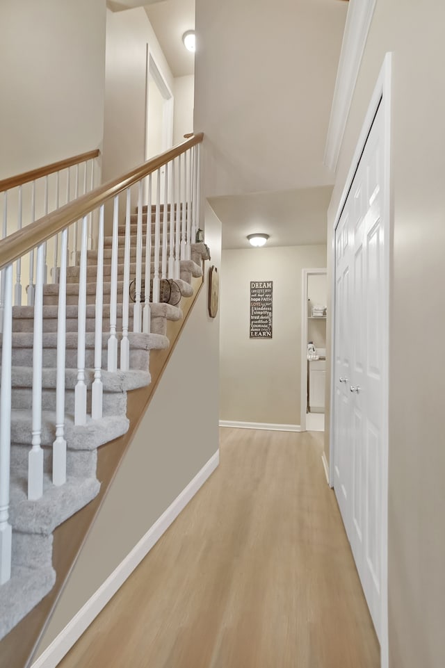 staircase featuring baseboards and wood finished floors