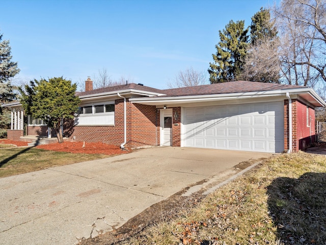 ranch-style house featuring a chimney, brick siding, an attached garage, and driveway