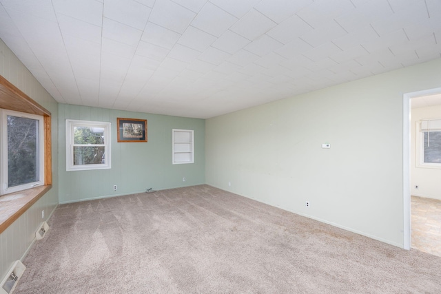 empty room featuring carpet floors and visible vents