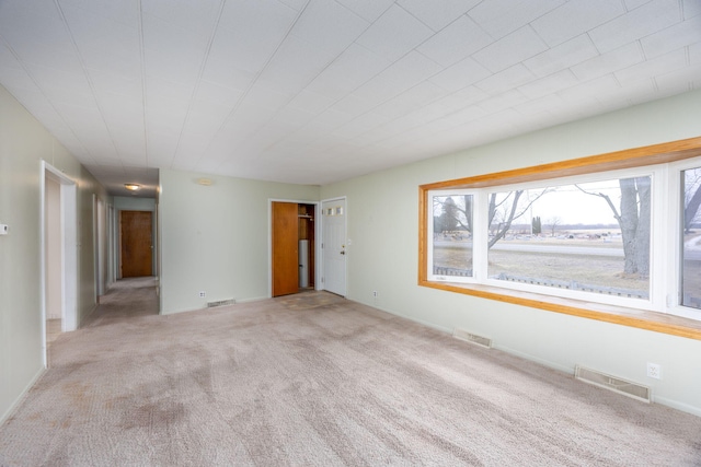 empty room featuring visible vents and carpet flooring