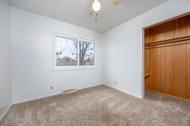 unfurnished bedroom featuring carpet flooring, visible vents, and baseboards