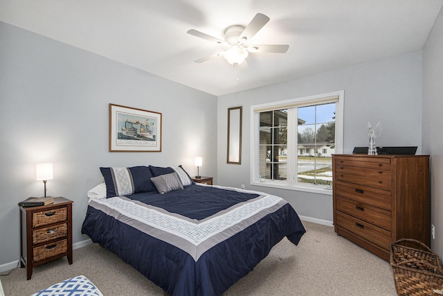 bedroom featuring a ceiling fan, light colored carpet, and baseboards